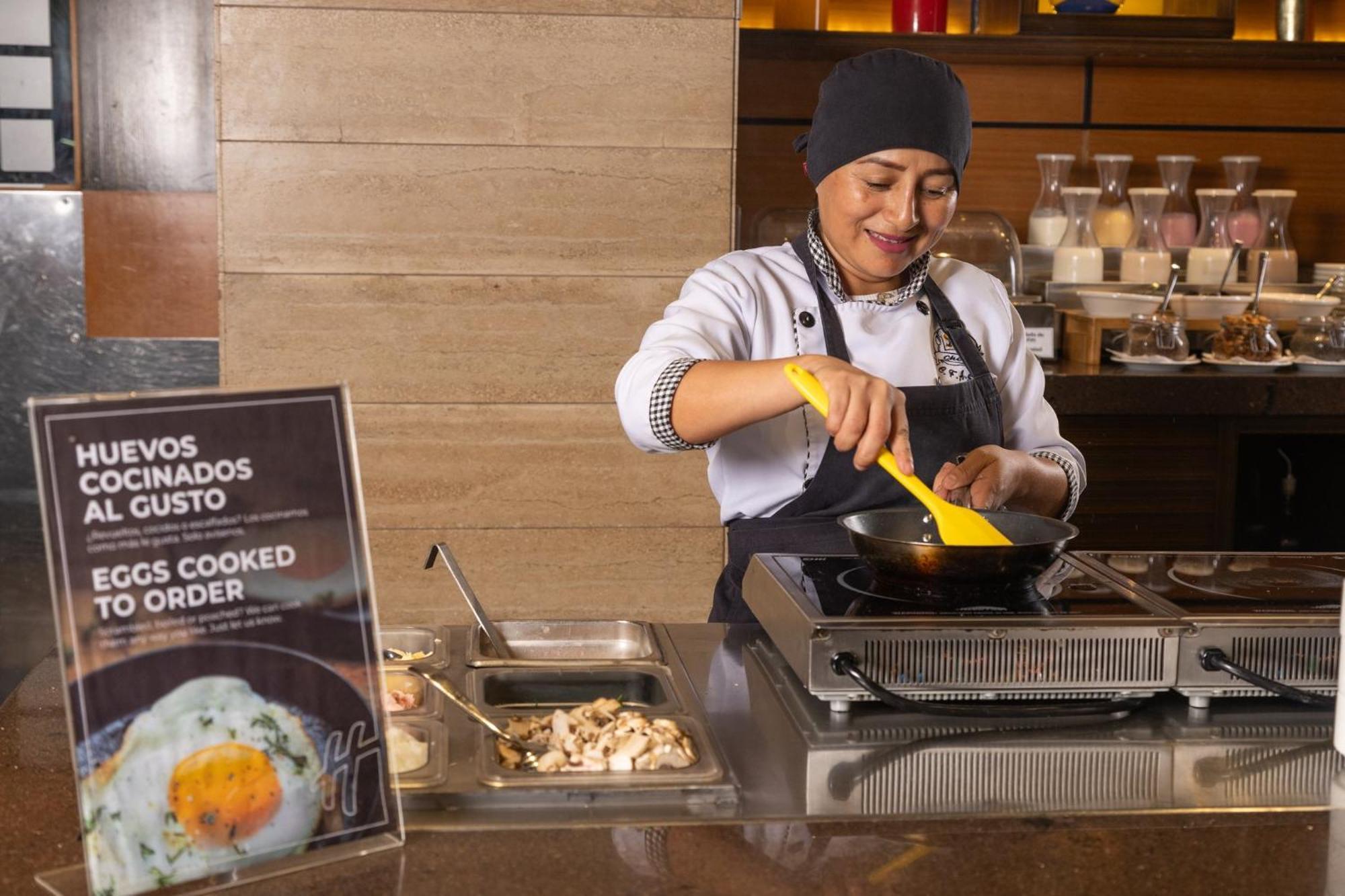 Holiday Inn Guayaquil Airport By Ihg Eksteriør billede A woman cooking eggs